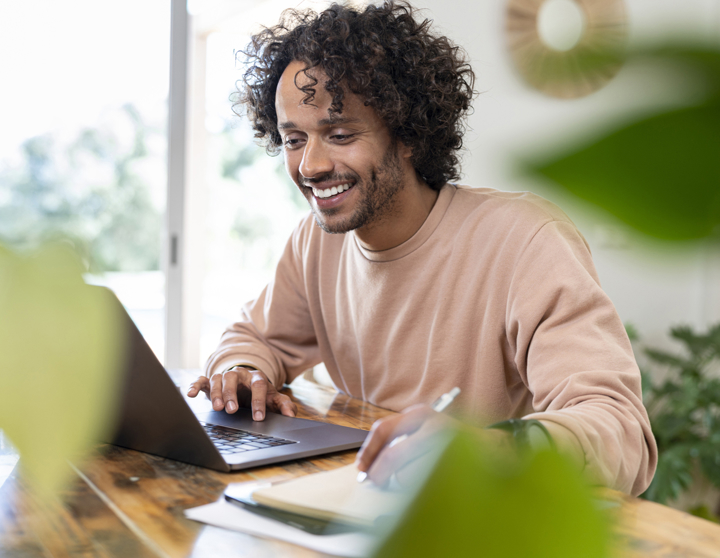 Junger Mann sichtlich entspannt am Laptop - ohne Stress