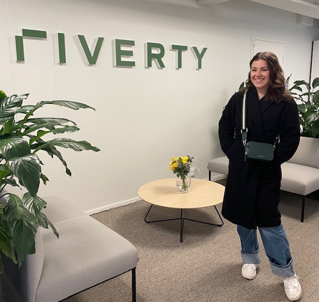 Thelma standing in front of Riverty's sign