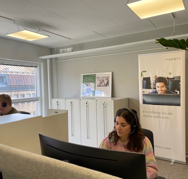 A picture of Thelma and her colleague working at their deck in the office