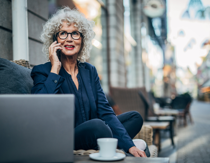 Mevrouw zit achter haar laptop en is aan het bellen