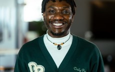 A picture of Timothy. He has short hair and is wearing a dark green outerwear.