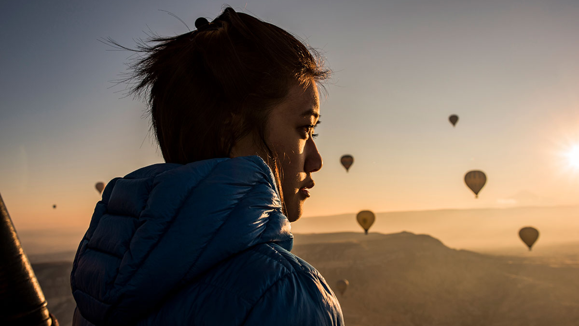 woman outdoors with hot air baloons