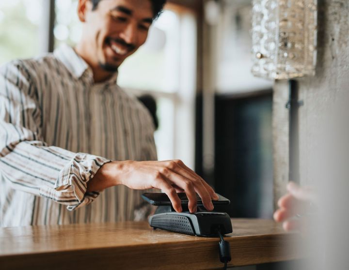 Een jonge man betaalt digitaal met zijn mobiele telefoon