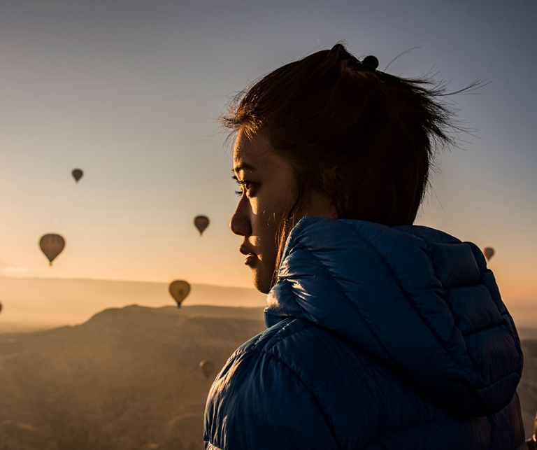 Woman outdoors with hot air baloons