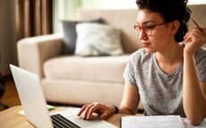 A young woman is researching the topic of insolvency proceedings on her laptop computer.