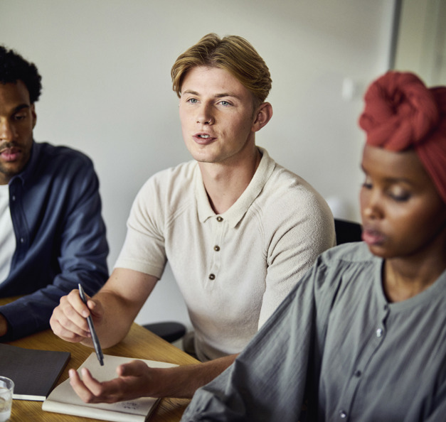 three students in a classroom being focused