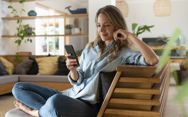 Frau mit Handy auf einem Sessel